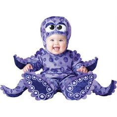 a baby in a purple octopus costume sitting on the ground with its mouth wide open