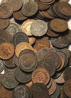 a pile of old coins sitting on top of each other in front of a white background