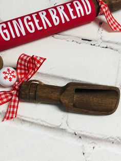 a gingerbread rolling pin next to a red and white christmas ribbon on a brick wall