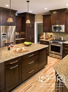 a large kitchen with wooden cabinets and granite counter tops, along with stainless steel appliances