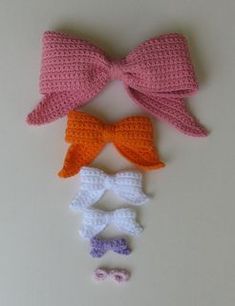 three crocheted bow ties are laying next to each other