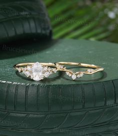 two gold rings with white stones on top of green tire treading surface, close up