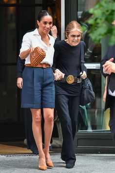 two women are walking down the street together