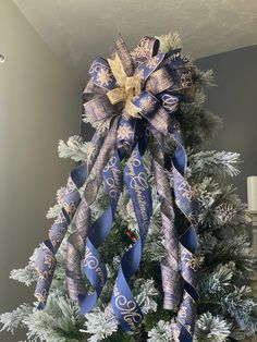 a decorated christmas tree with blue and gold ribbons