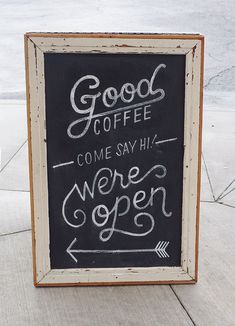 a chalkboard sign that says good coffee come say hi were open