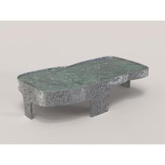 a small table made out of concrete with a green pattered finish on the top