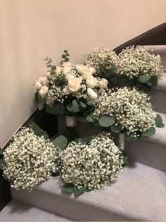 some white flowers are sitting on the stairs