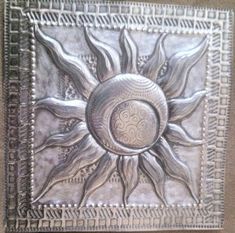 a decorative metal wall hanging with the sun and moon on it's center piece