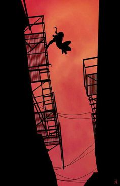 the silhouette of a person on a skateboard high up in the air near fire escapes