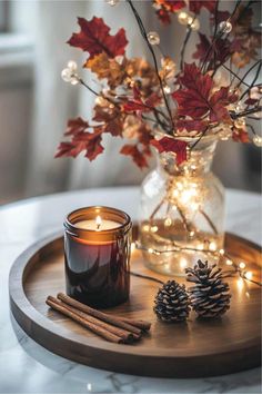 a candle and some cinnamon sticks on a tray