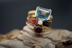 Ring wide: 0.75''/19.5mm Band wide: 0.37''-0.2''/9.8mm-5.2mm This statement ring is made of topaz, tourmaline, opal, diamond, and 18K gold. It's gorgeous and elegant. Perfect for any occasion. Thank you for your interest. Please check out our other items and be sure to add us to your favorites! We look forward to the opportunity of serving you. Formal Multi-stone Tourmaline Ruby Ring, Formal Multi-stone Ruby Ring With Tourmaline, Luxury Multi-stone Tourmaline Ring, Formal Multi-stone Tourmaline Sapphire Ring, Luxury Multi-stone Sapphire Ring With Tourmaline, Diamond Topaz Ring, Garnet Bead Bracelet, Opal Diamond Ring, Multi Gemstone Ring