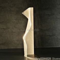 the light is shining on the floor next to the lamp in the dark room with concrete walls