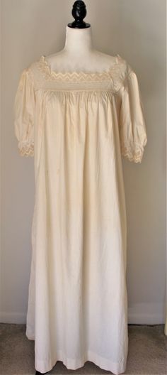 "I bought this in the early 80s at my very first estate sale and it was my first antique/vintage nightgown. When I visit my parents, I drive by the home where the estate sale was and I always think of this nightgown and a gorgeous top and skirt from the same era that I bought. This has been on a mannequin as a display item for years but it's time to find her a new home.  The gown is ankle length with short sleeves. It trimmed in crocheted lace at the neck and sleeves and slips over the head.  Given it's age, 100 years old or more, it is in Very good to excellent antique condition. The seams and fabric are still very strong with no holes, tears or weakening but there are scattered stains throughout, most of them are not easily noticed but I have included photos of the large ones. She has ma Vintage Nightgown For Wedding Night, Vintage Cotton Nightgown For Weddings, Vintage Wedding Nightgown, Vintage Cream Sleepwear For Wedding Night, Cream Prairie Dress With Lace Trim For Daywear, Vintage Nightgown With Lace Trim For Bedtime, Cream Victorian Dress With Lace Trim For Daywear, Cream Victorian Vintage Dress For Daywear, Vintage Cream Nightgown For Loungewear