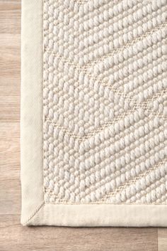 a white rug on top of a wooden floor