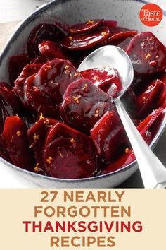 a pot filled with lots of red food on top of a wooden table next to a spoon