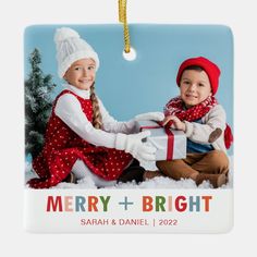 two children are holding a christmas present on a glass ornament that says merry and bright