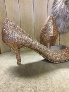 "These beautiful glitter high heels are covered in a rose gold glitter and sealed with a two step sealant that allows for movement and will not dull the shin of the glitter. This rose gold color is best described as a gold with a rose undertone. It is not an externally pink rose gold but does have a beautiful hint of pink undertones. Please note that the example heels in the photo are a size 8 shoe with a 3\" heel. Sizes 5-12 are available at checkout along with three different heel heights. All Gold Closed Toe Heels For Prom, Gold High Heel Court Shoes With 4-inch Heel, Gold Wedding Shoes With 4-inch Heel, Gold Court Shoes With 4-inch Heel And Almond Toe, Gold Low Heel Heels For Prom, Gold Heels With Round Toe, Gold Shimmer Heels For Prom, Gold Sparkling Low Heel Shoes, Gold Fitted Court Shoes With Low Heel