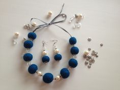 a necklace and earring set made from felt beads, pearls and swaroons