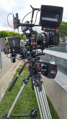 a camera on a tripod sitting in the grass