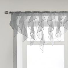 a window with sheer curtains hanging from it's side