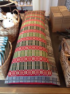 a bed sitting on top of a wooden table next to baskets