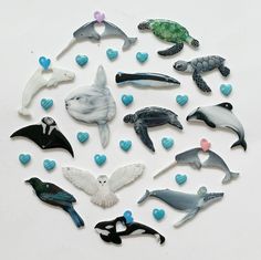 various sea animals and birds are arranged in a circle on a white surface with hearts