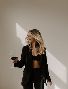 a woman holding a glass of wine in her hand