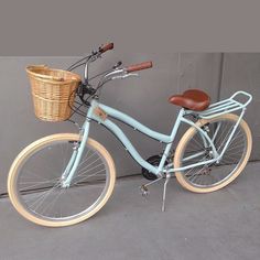 a blue bicycle parked next to a wall with a wicker basket on the front