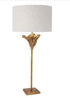 a gold lamp with a white shade on the base and a wooden stand underneath it