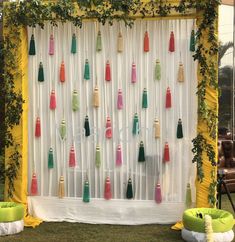 the backdrop is decorated with colorful tassels and greenery