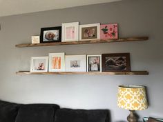 a living room filled with furniture and framed pictures on the wall above a black couch