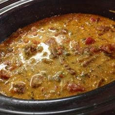 a crock pot filled with food sitting on top of a stove