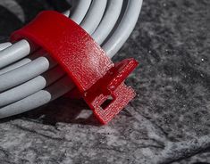 a red and white extension cord connected to an electrical outlet on top of a granite surface