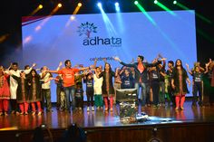 a group of people standing on top of a stage with their arms in the air