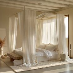 a bed with white drapes and pillows in a room that looks like it has been made into a canopy