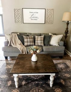 a living room with a couch, coffee table and two pictures on the wall above it