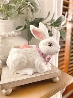 a white rabbit figurine sitting on top of a wooden table