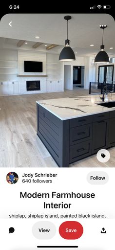 an open floor plan for a kitchen with white cabinets and black island in the middle