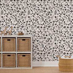 the wallpaper in this room is decorated with black and white floral designs, which are accented with wicker baskets