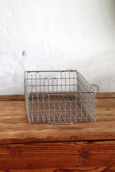 a metal basket sitting on top of a wooden table