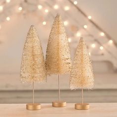 three small white trees sitting on top of a table