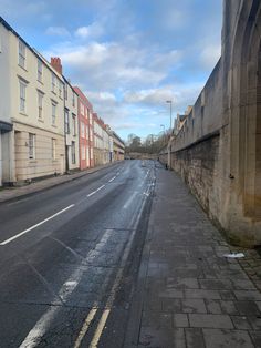 an empty street with no cars on it and buildings lining both sides in the distance