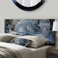 a bed with pillows and blankets in front of a wall mounted clock on the wall