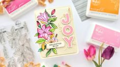 a card with the word joy on it next to some flowers and crayons