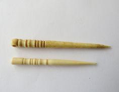 two carved wooden objects sitting on top of a white surface