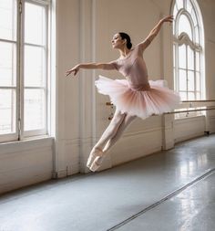 a ballerina in a pink tutu is posing for the camera