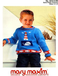 a young boy wearing a blue sweater with a lighthouse on it