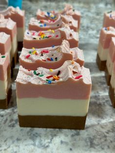 several pieces of cake with sprinkles on them sitting on a counter top