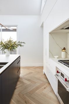 a kitchen with an oven, stove and counter tops in white painted wood flooring