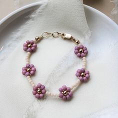 Welcome little ones in style with this beautiful Peony Bracelet. The purple flower daisy chain is perfect for toddlers and babies, and sure to be treasured by the special little one in your life. Made to last with 14k gold filled hardware. Comes in baby though adult sizes. Check out our size guide for help with sizing. We look forward to seeing you and your sweet little ones wearing your bracelets #joyfulbead. * Due to the nature of our handmade bracelets and the beads they might vary slightly. Spring Bracelets, Seed Bead Bracelets Tutorials, Toddler Bracelet, Bracelet For Girls, Easter Presents, Beaded Things, Music Crafts, Spring Bracelet, Flower Daisy